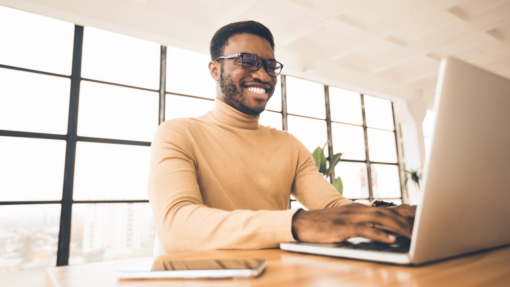 Happy black guy updating his personal online blog